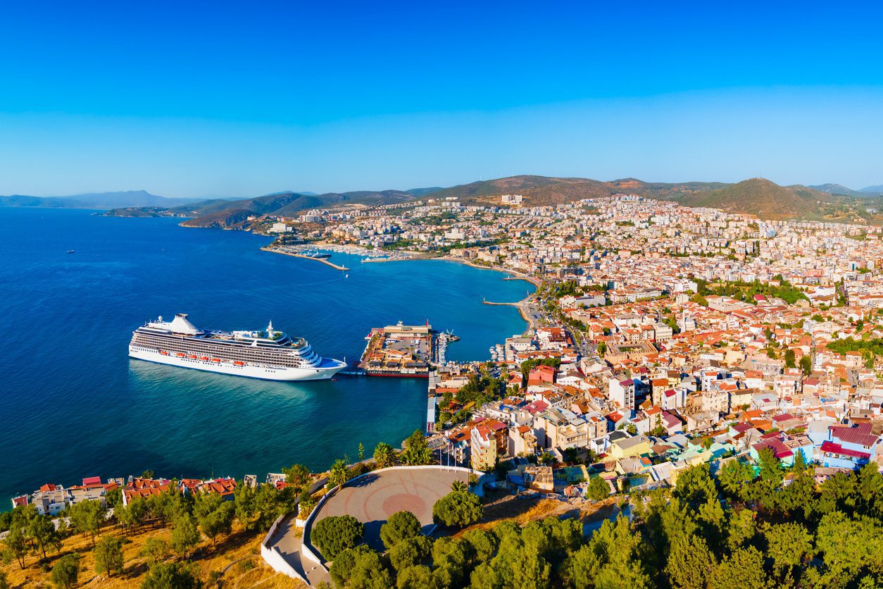 Large cruise ship docked at a Mediterranean port city, representing holiday packages with a cruise ship travel agent