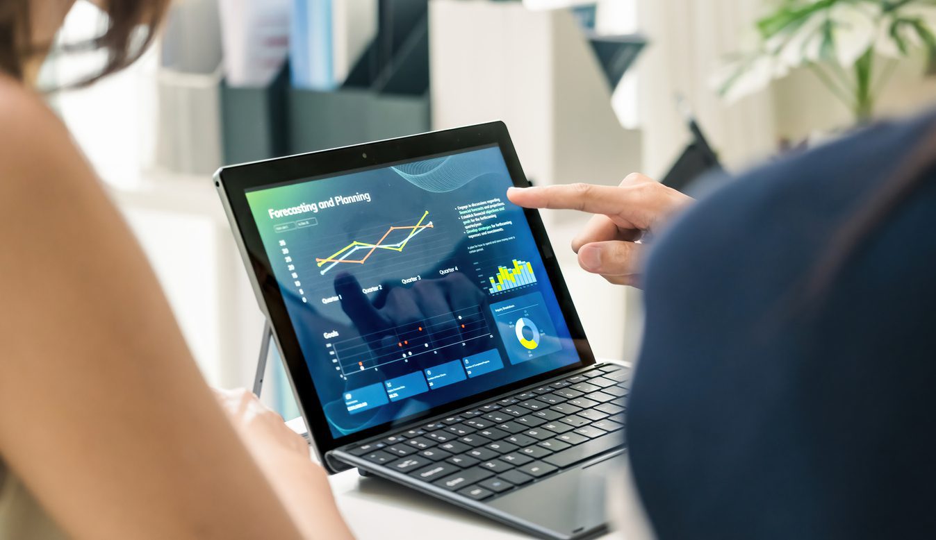 Travel agent using accounting software on a laptop to track bookings and financial reports.