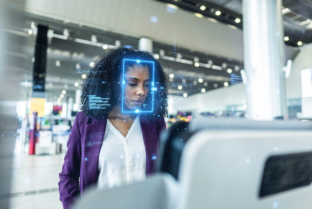 Passenger using biometric facial recognition at airport kiosk powered by cloud-based AI